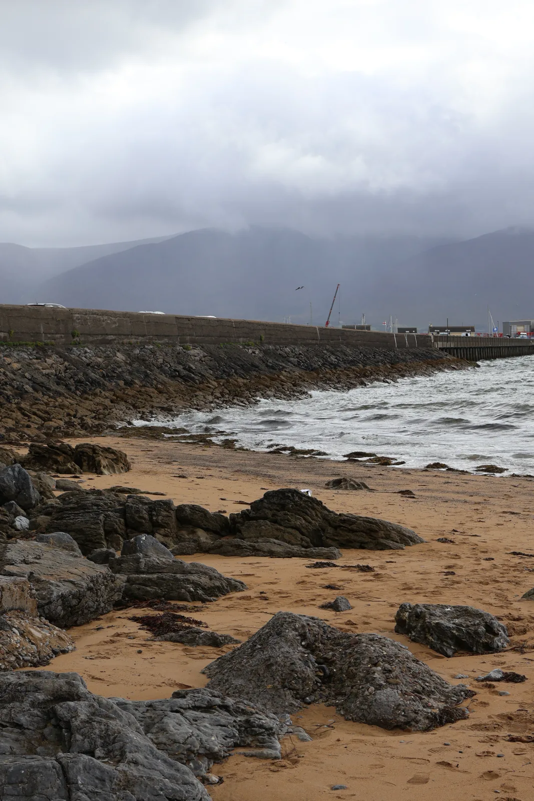 Fenit beach at low tide with the harbour wall and Slieve Mish mountains in the distance